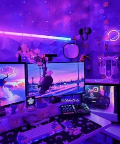 two computer monitors sitting on top of a desk in front of a purple wallpaper