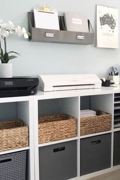 a white shelf filled with baskets next to a printer