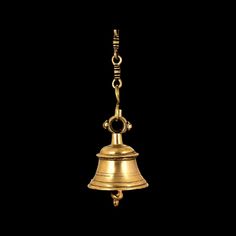 a golden bell hanging from a chain on a black background