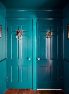 two blue doors in a room with wood floors