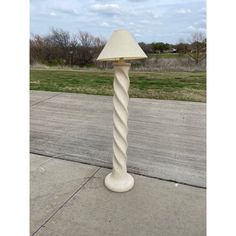 a white lamp sitting on top of a sidewalk