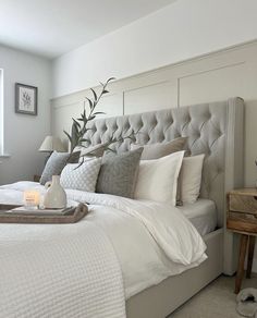 a bedroom with white walls and beige bedding