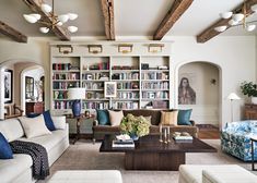 a living room filled with lots of furniture and bookshelves covered in bookcases