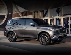 the new infiniti suv is parked outside an office building with its doors open