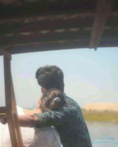 a man and woman embracing each other on a boat