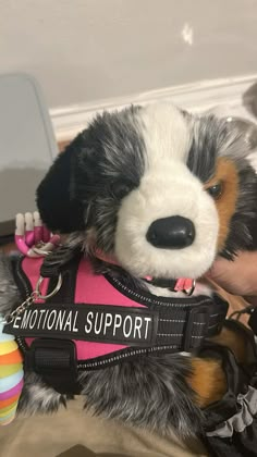 a stuffed animal is wearing a pink vest