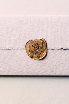 a gold coin sitting on top of a white envelope