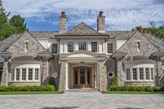 a large stone house with white trim and windows