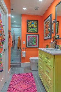 a bathroom with orange walls and colorful rugs