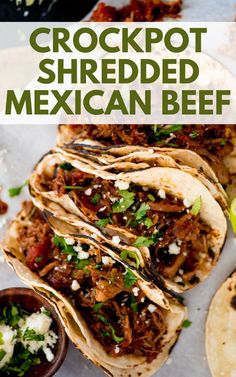 the crockpot shredded mexican beef tacos are ready to be eaten and served