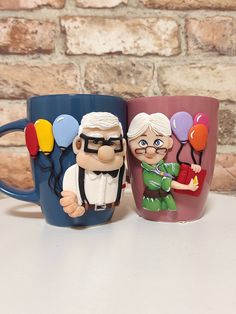 two coffee mugs with cartoon characters on them