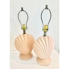 two shell shaped lamps are sitting on a table