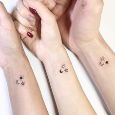 three wrist tattoos with stars, moon and sun on each one arm in black ink