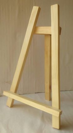 a wooden easel sitting on top of a white sheet