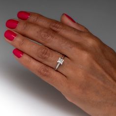 a woman's hand wearing a diamond ring