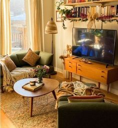 a living room filled with furniture and a flat screen tv on top of a wooden table