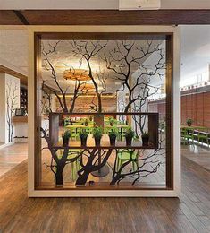 the inside of a building with wooden floors and glass doors that have trees painted on them