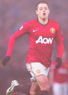 a man in red jersey kicking a soccer ball