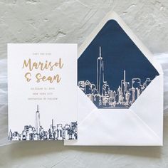 an envelope with a city skyline printed on the front and inside is open to reveal a card that says, save the date