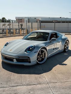 a silver sports car parked on top of a parking lot