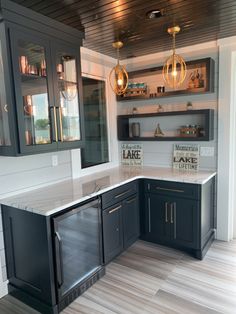 a kitchen with black cabinets and white counter tops