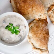 some food is on a white plate with a small bowl of dipping sauce next to it