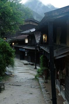 an alley way with buildings and trees on both sides, in the foggy day