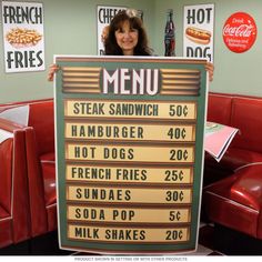 a woman holding up a menu sign in a restaurant