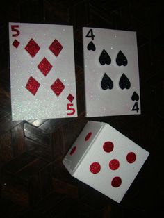 two playing cards with red and black dots on them