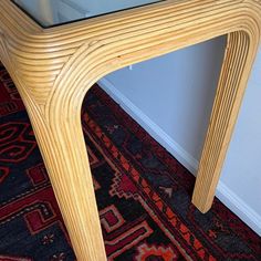 a wooden table with glass top sitting on a rug