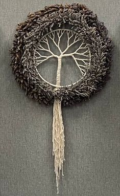 a decorative piece with a tree hanging from it's center, made out of yarn