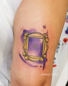 a purple and yellow frame tattoo on the arm