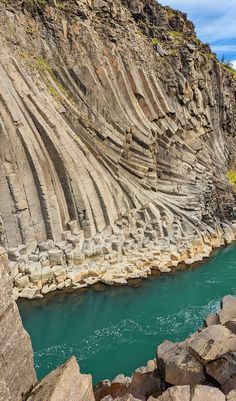 the water is blue and green in this rocky area with large rocks on either side