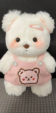 a white teddy bear wearing a pink shirt