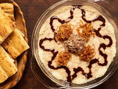 a bowl filled with food next to some pita bread