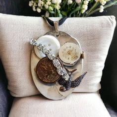 a clock and other items are on a plate next to a bouquet of white flowers