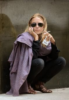 a woman sitting on the ground talking on her cell phone