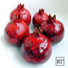 four red pomegranates sitting on top of each other