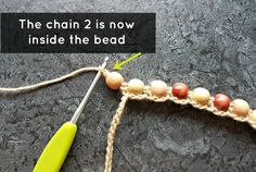 the chain 2 is now inside the bead with an orange handled crochet hook