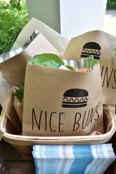 some brown paper bags filled with food on top of a wooden table next to plants