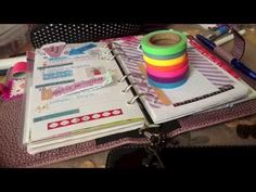 a binder with some tape on top of it next to pens and other items