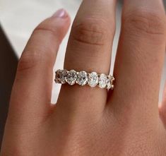 a woman's hand with a five stone diamond ring on her left hand,