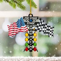 an ornament hanging from a christmas tree with flags on it and snowing in the background