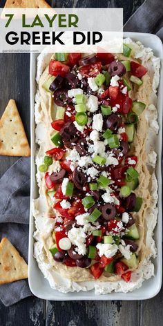 a platter filled with different types of appetizers and crackers on the side