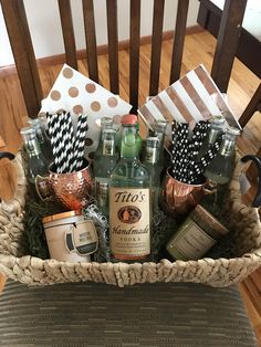 a basket filled with liquor bottles and paper straws on top of a wooden chair