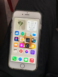 an iphone is sitting on someone's lap with the screen showing various app icons