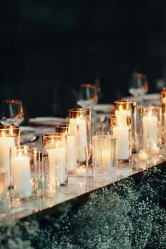 candles are lined up on a long table