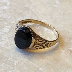 a gold ring with a black stone on it