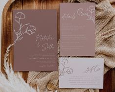 the wedding stationery is laid out on a wooden tray