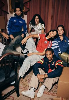 a group of young people sitting on top of a couch in a living room next to each other